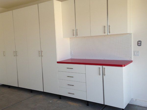 A kitchen with white cabinets and a red counter top