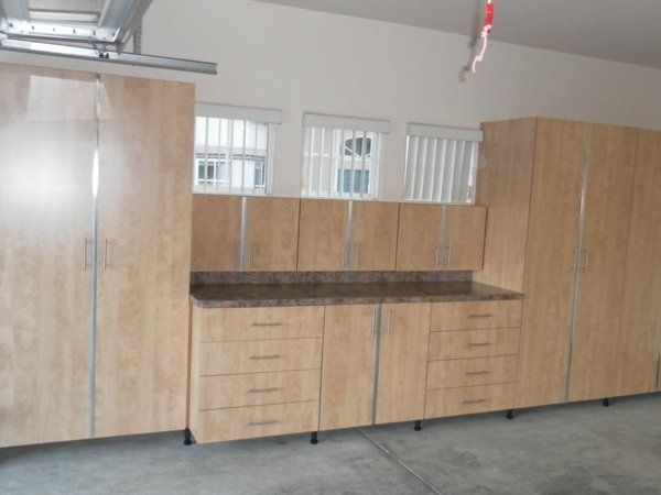 A garage with lots of wooden cabinets and drawers