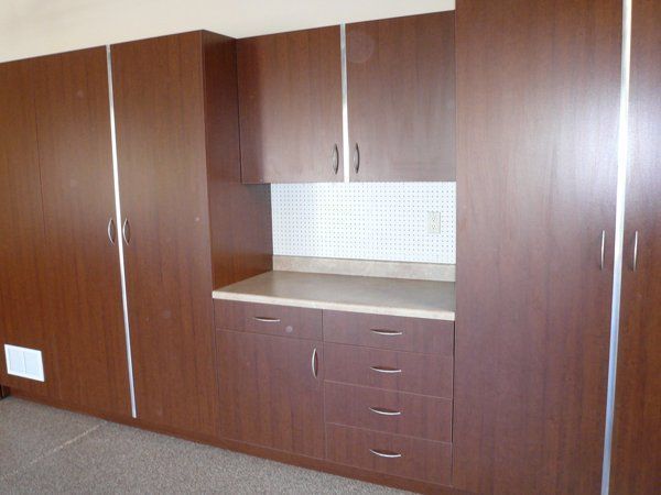 A kitchen with lots of wooden cabinets and drawers