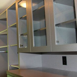 A kitchen with a lot of glass doors and shelves