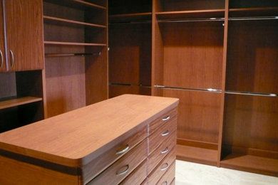 A walk in closet with lots of shelves and drawers