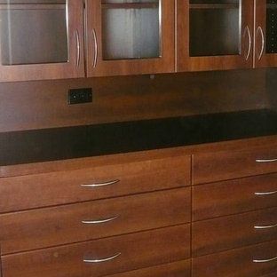 A kitchen with wooden cabinets and drawers and a black counter top