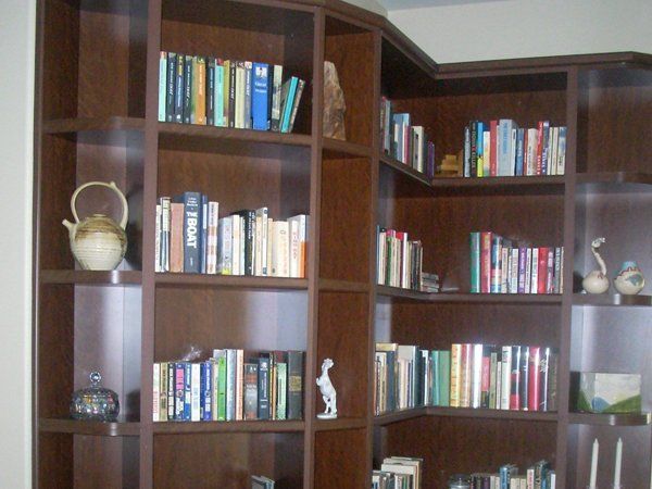 A bookshelf filled with books and a teapot