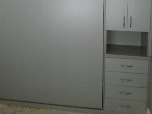 A closet with a shelf and drawers underneath it