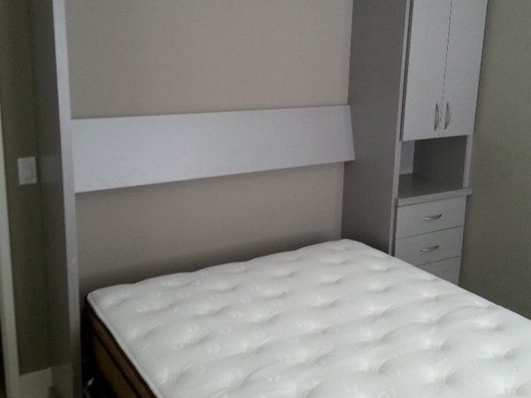 A bed with a white mattress is sitting in a bedroom.