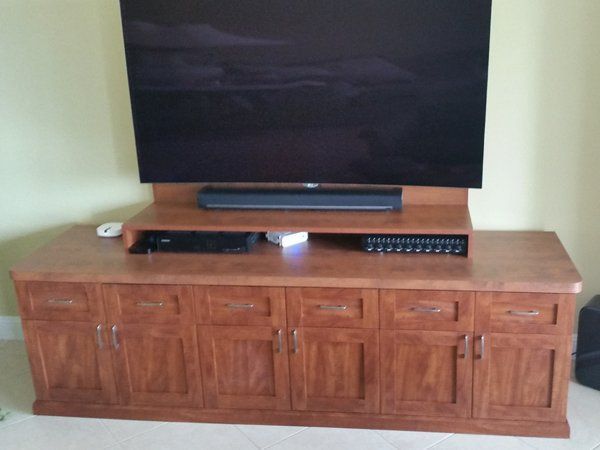 A large flat screen tv is sitting on top of a wooden entertainment center