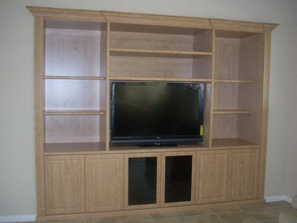 A large entertainment center with a flat screen tv on top