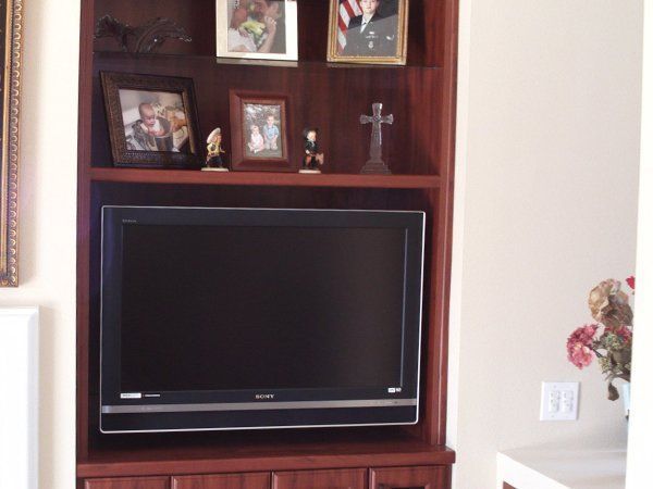 A wooden entertainment center with a flat screen tv