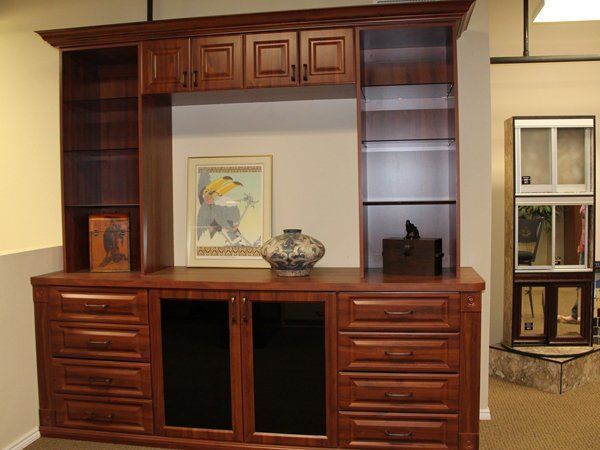A wooden cabinet with drawers and a picture on the wall