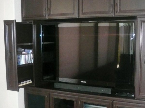 A flat screen tv is in a cabinet with the doors open