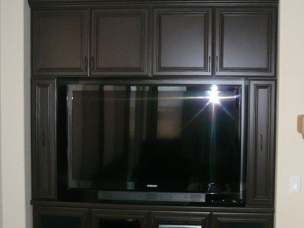 A large flat screen tv is sitting in a cabinet