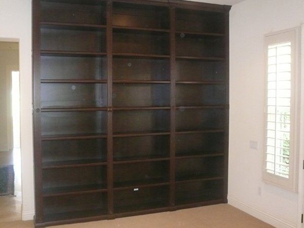 A large bookshelf in a room with a window
