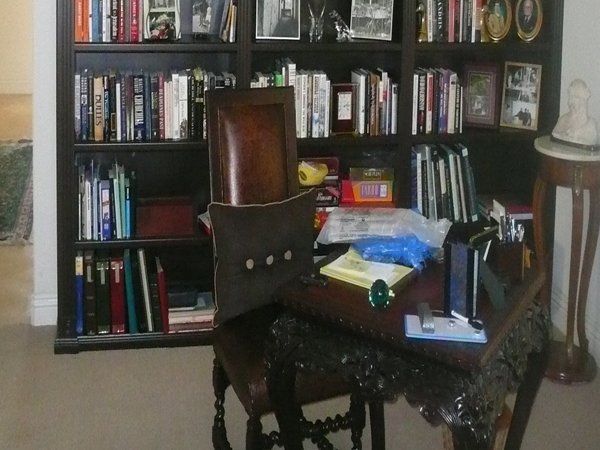 A chair sits in front of a bookshelf filled with books