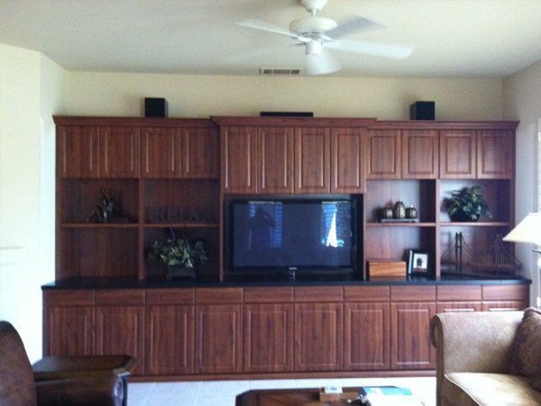 A living room with wooden cabinets and a flat screen tv