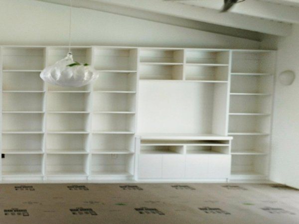 A room with a lot of shelves and a chandelier hanging from the ceiling