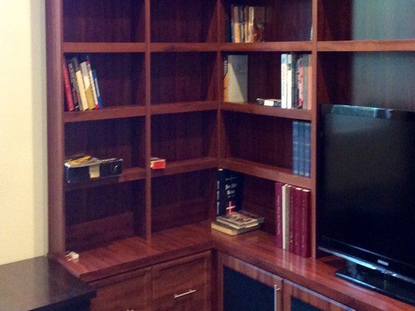 A living room with a bookshelf and a flat screen tv