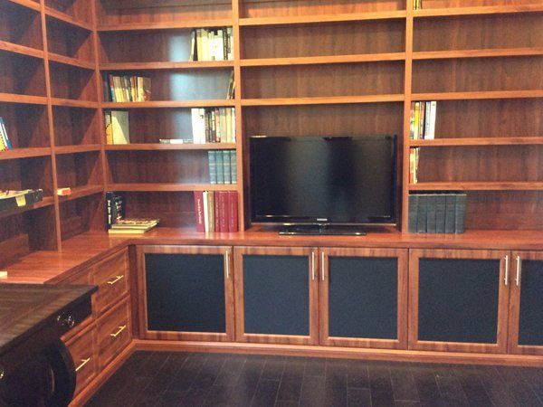 A library with lots of shelves and a flat screen tv