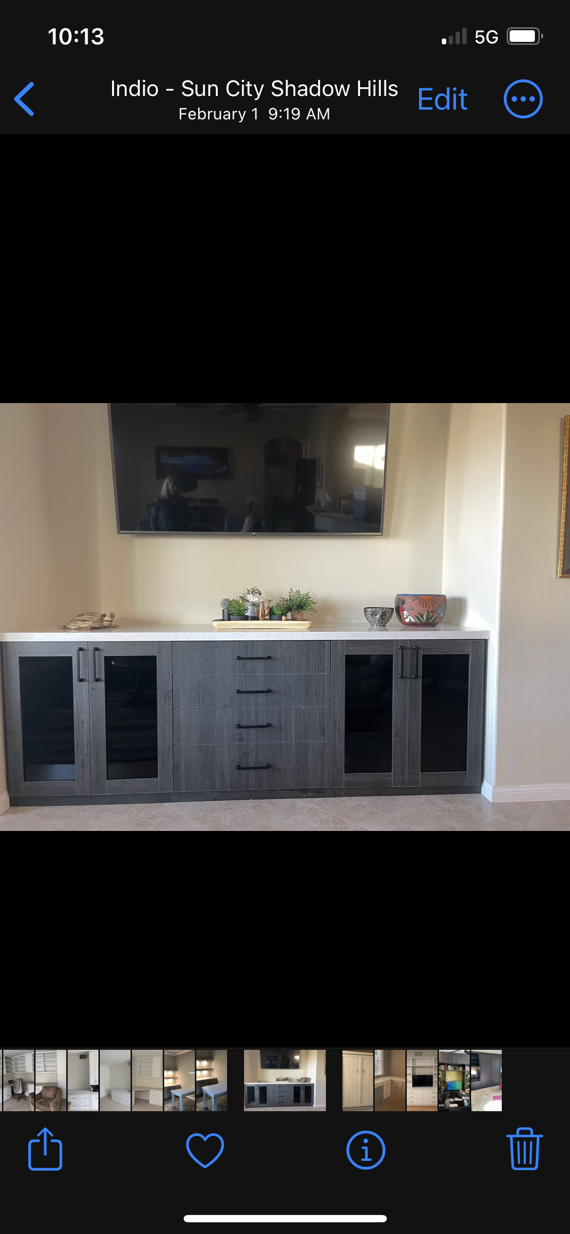 A picture of a kitchen with black cabinets and a flat screen tv.