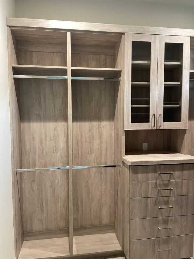 A walk in closet with lots of shelves and drawers.