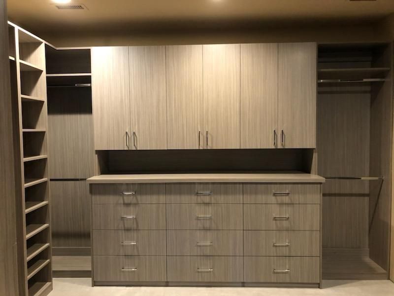 A walk in closet with lots of drawers and cabinets