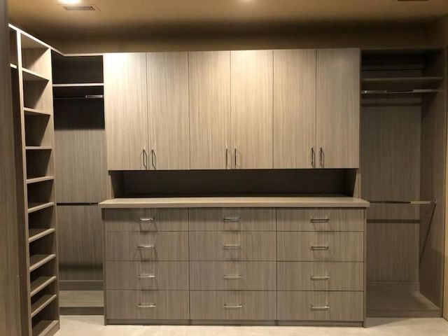 A walk in closet with lots of drawers and cabinets