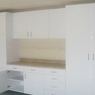 A kitchen with white cabinets and drawers and a counter top.