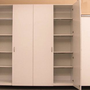 A row of white cabinets with shelves and doors open.