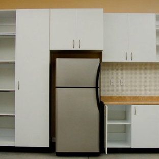 A kitchen with white cabinets and a stainless steel refrigerator