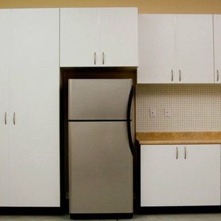 A kitchen with white cabinets and a stainless steel refrigerator