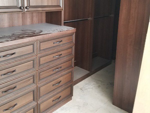 A walk in closet with lots of drawers and cabinets