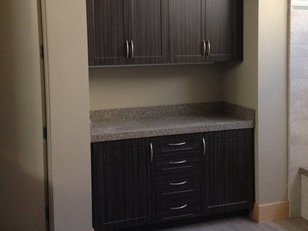 A kitchen with dark cabinets and granite counter tops