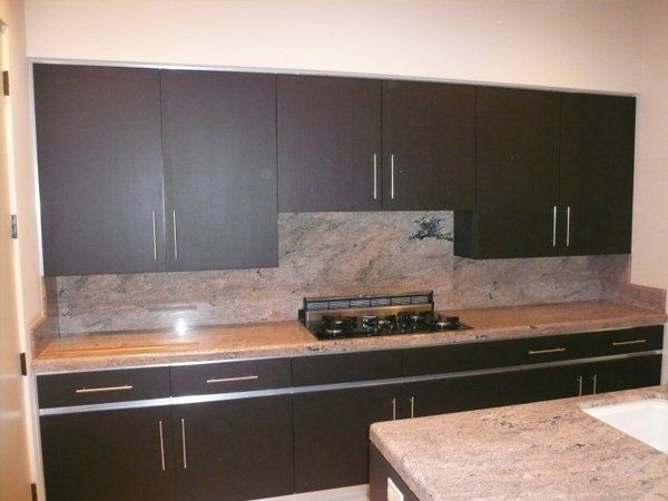 A kitchen with brown cabinets and a stove top oven