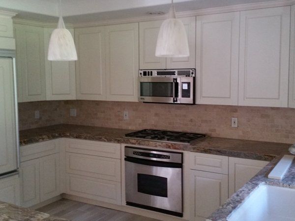 A kitchen with white cabinets and stainless steel appliances