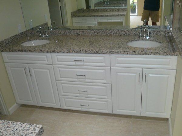 A bathroom with two sinks and a large mirror