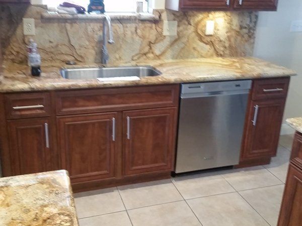 A kitchen with a sink and a stainless steel dishwasher
