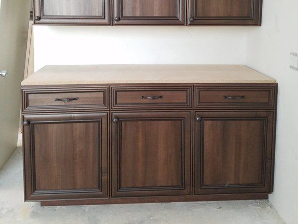 A wooden cabinet with three drawers and three doors