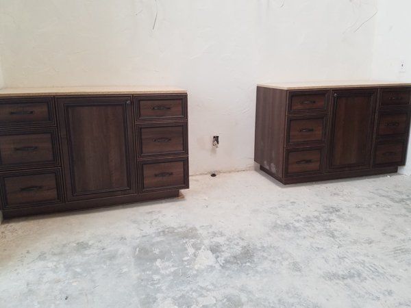 Two wooden cabinets are sitting next to each other in a room.