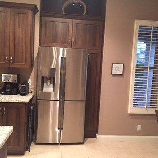 A kitchen with a stainless steel refrigerator and a window