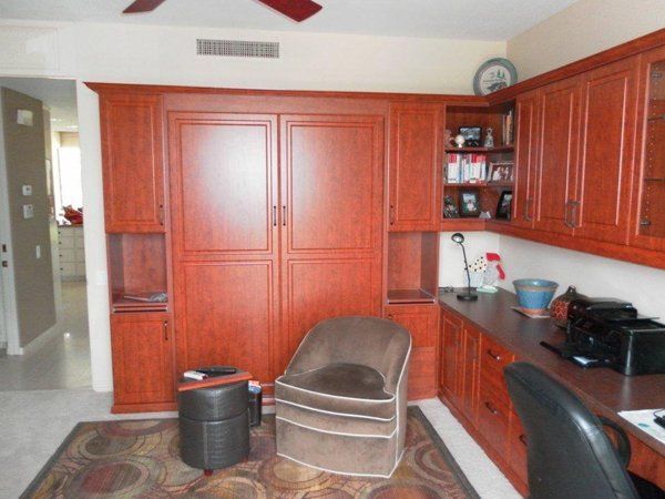 A room with a chair and a desk with a ceiling fan