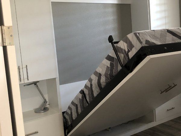 A bed that is pulled out of the wall in a room