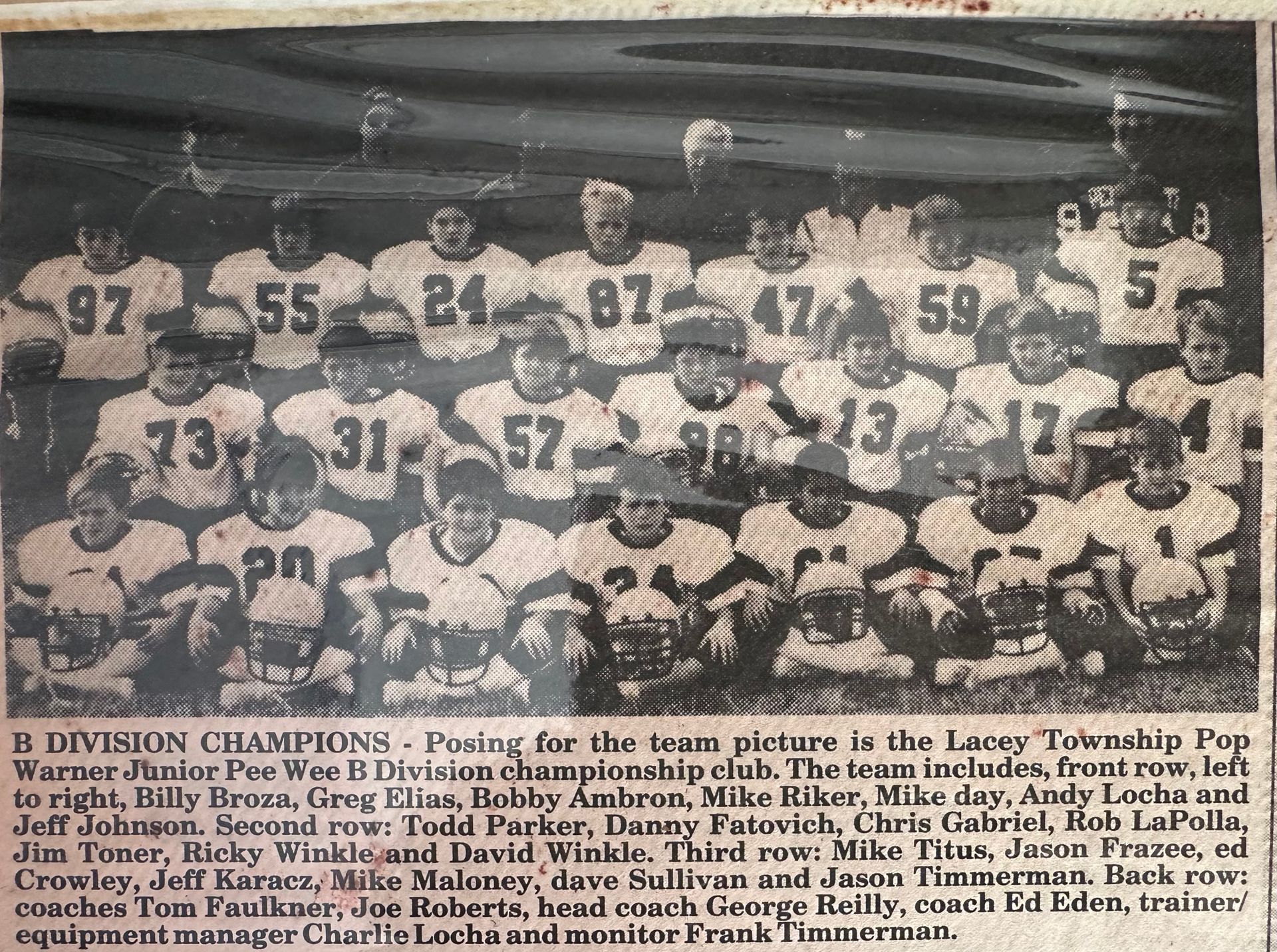 Black and white photo of a football team. Players in numbered jerseys, posing for a group shot.