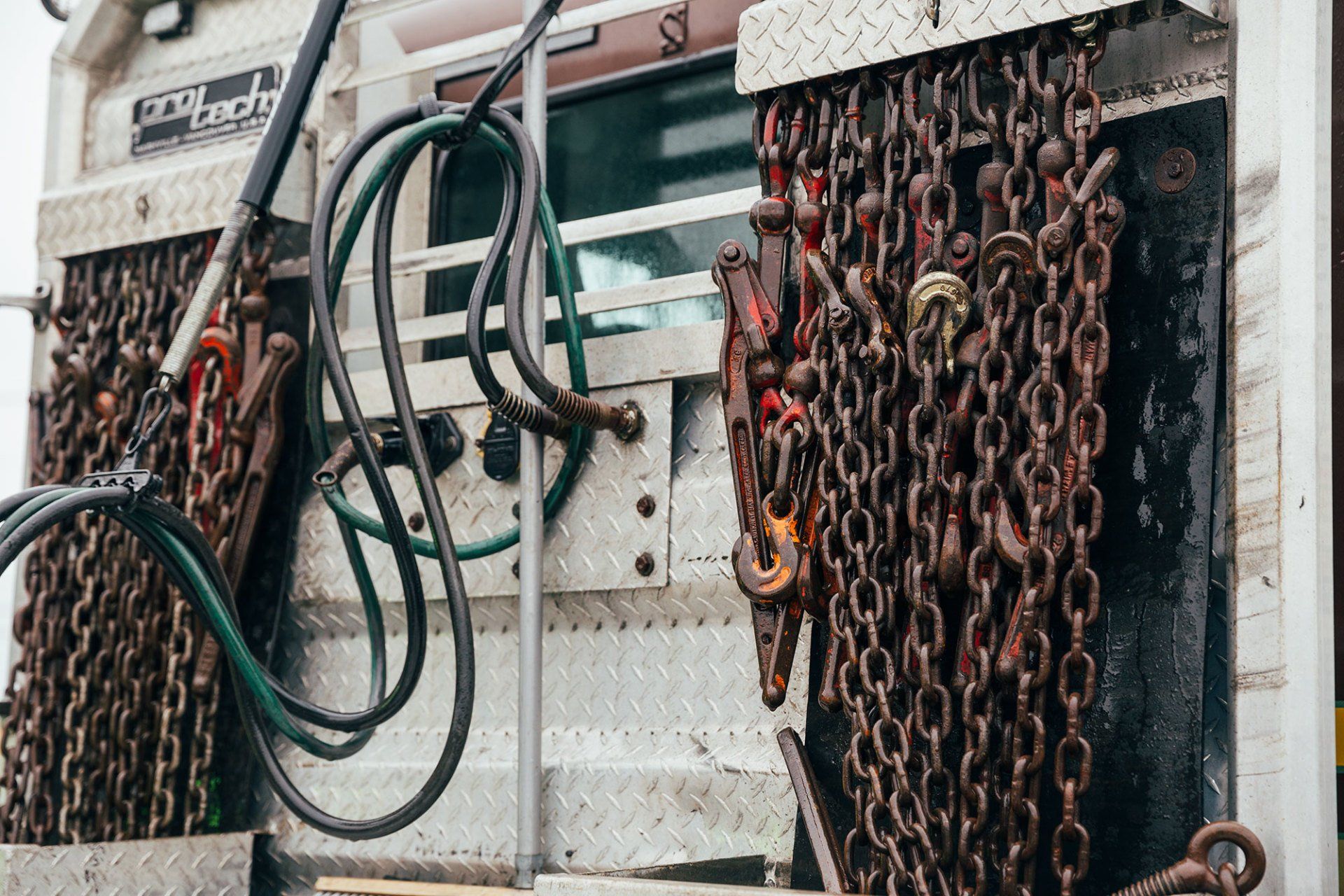 A close up of a truck with chains and hose attached to it.