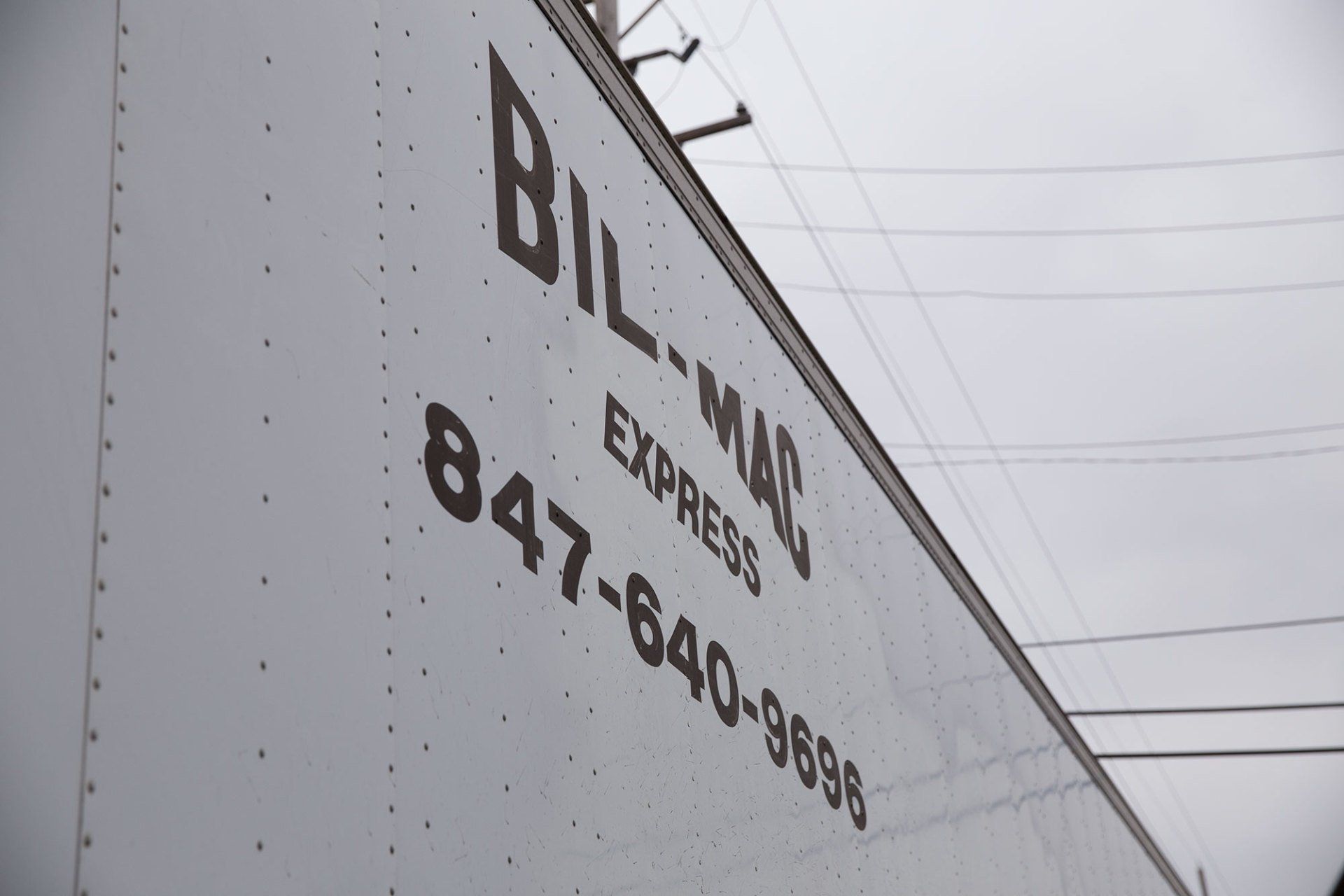 A bill-man express truck has a phone number on the side