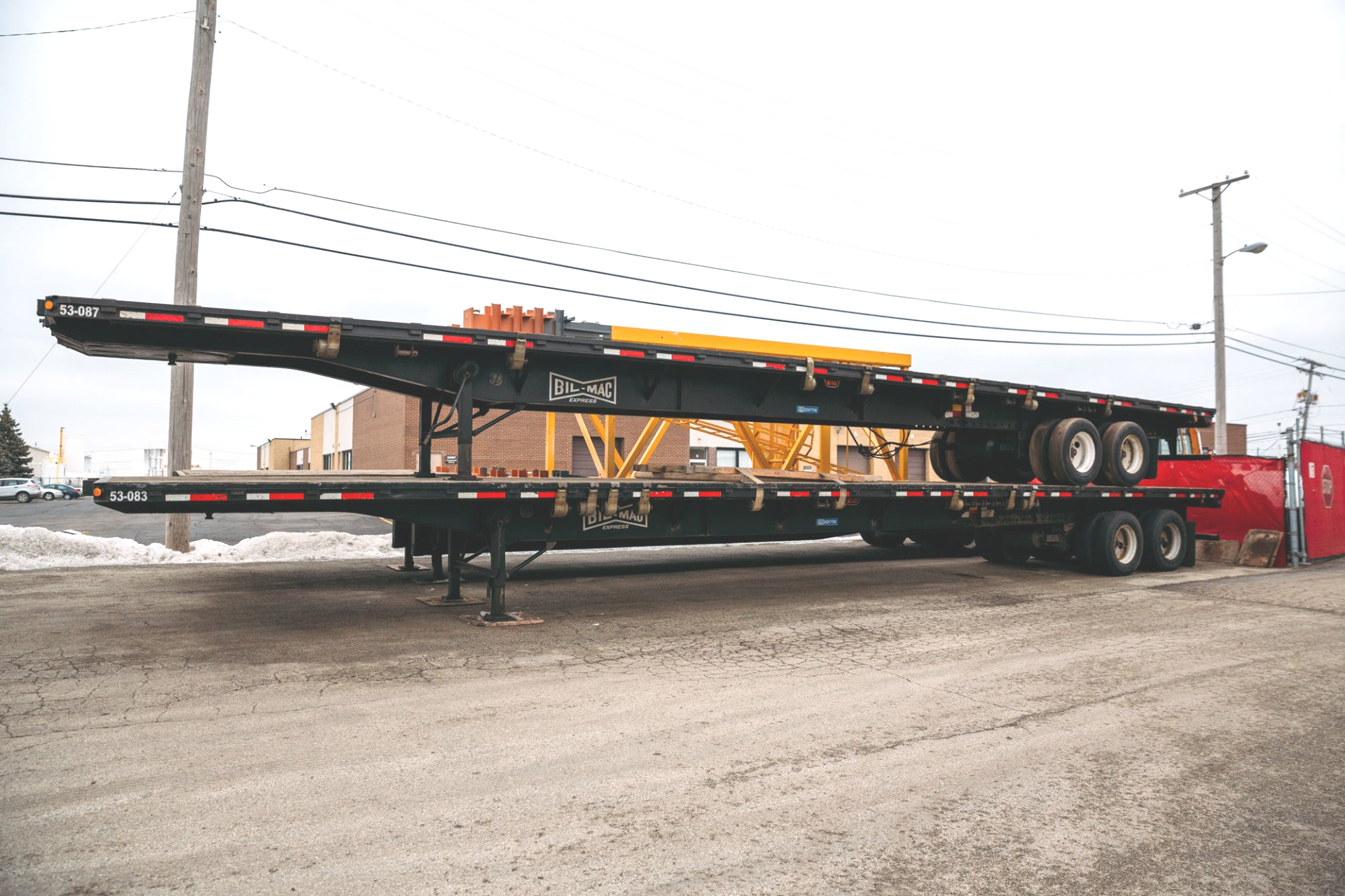 A very long trailer is parked on the side of the road.