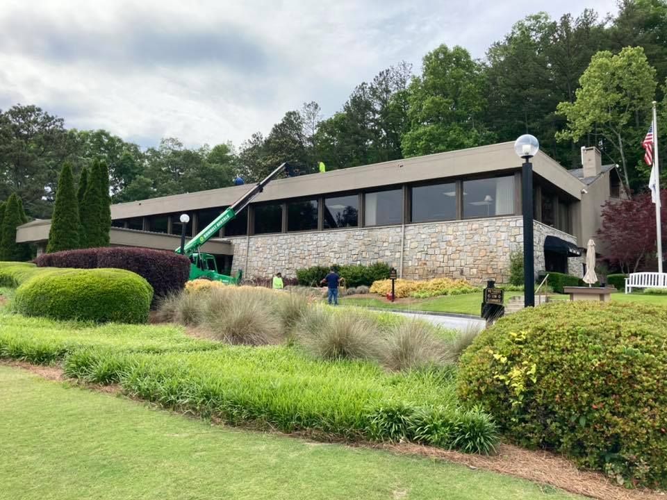 Building with stone facade and flat roof, surrounded by landscaping, 