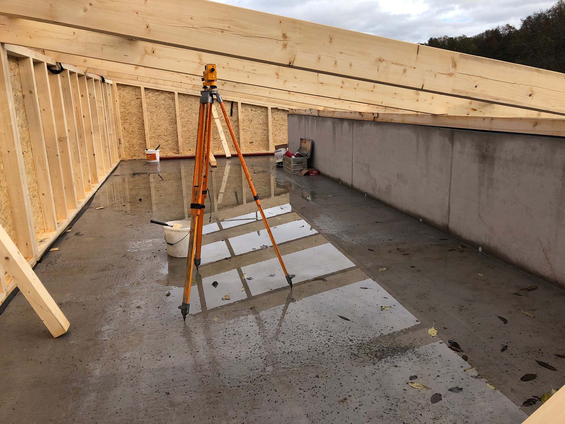 A tripod is sitting in the middle of a building under construction