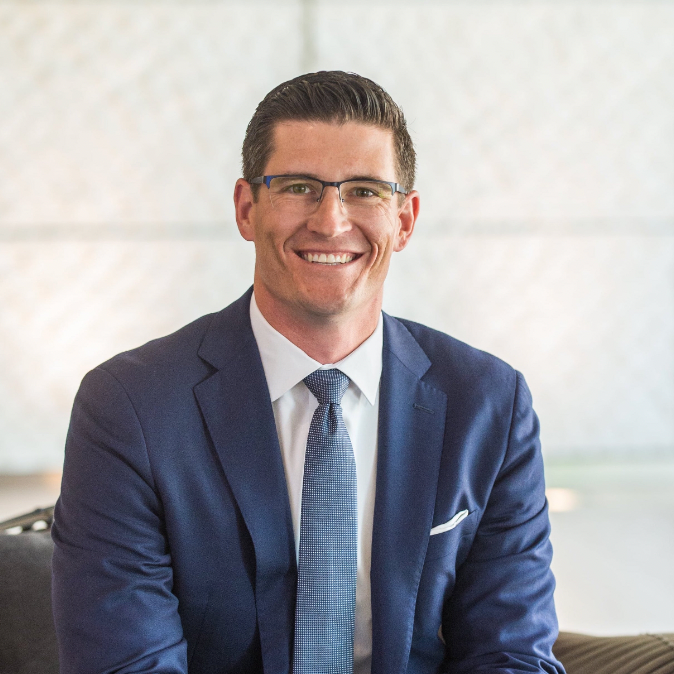 A man in a suit and tie is smiling for the camera