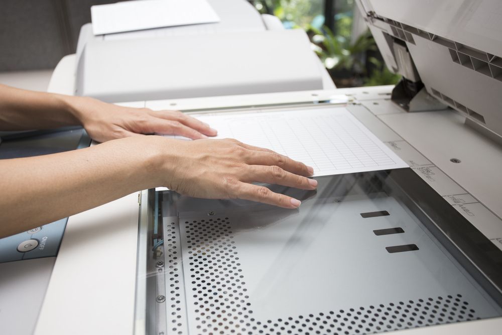 Woman Putting A Sheet On Copier Machine — Copy Shop in Dubbo, NSW