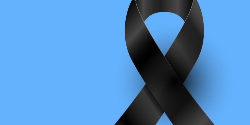 Black ribbon on a light blue background, symbolizing mourning or awareness.