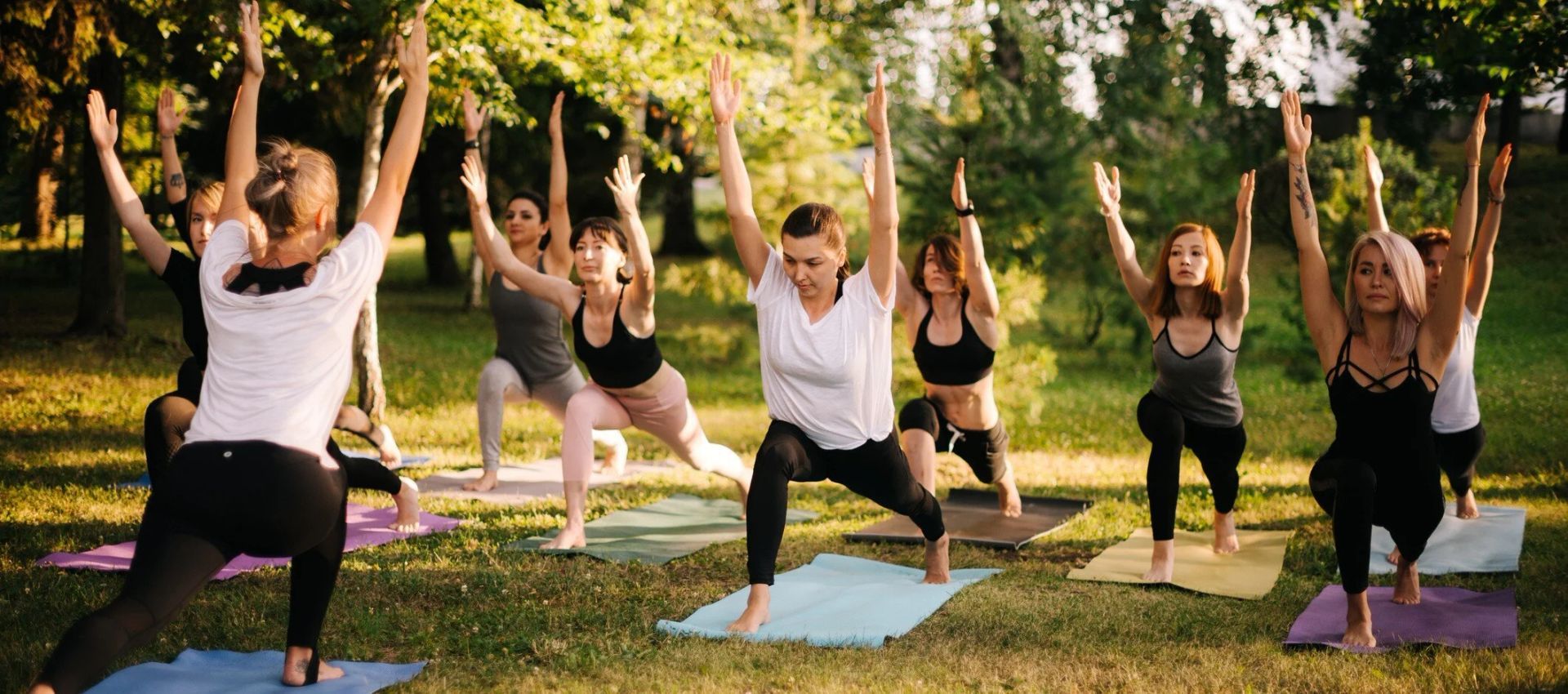 A group of people are practicing yoga in a park.